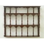 Early 19th century mahogany wall mounted three tier delft rack fitted with turned supports, W111cm,