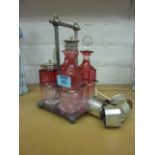 Early 20th century cranberry glass cruet set with Victorian hallmarked silver tea spoon and four