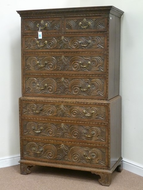 Early 19th century heavily carved oak chest on chest fitted with two short and six long drawers,