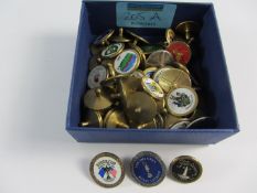 Collection of brass golf club ball markers including Ryder Cup and Open championships