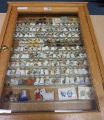 Collection of thimbles in oak display case 62.