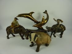 Two oriental sculptures of children riding water buffaloes,
