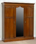 Edwardian walnut triple wardrobe enclosed by three doors, one glazed with bevelled mirror,