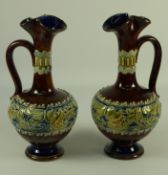 Pair Royal Doulton Lambeth stoneware ewers decorated with frogs on lily pads,