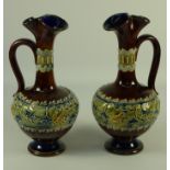 Pair Royal Doulton Lambeth stoneware ewers decorated with frogs on lily pads,