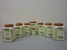 Set of eight 1930s kitchen storage jars with wooden lids H19cm diminishing