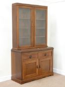 Late Victorian walnut bookcase enclosed by two glazed doors on cupboard fitted with two drawers and