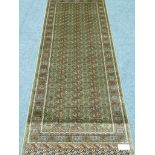 Persian Bokhara design green ground runner rug,