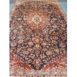 Persian Kashan central medallion red and blue ground rug,