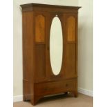 Edwardian inlaid mahogany wardrobe enclosed by oval glazed mirror door and drawer to base, W128cm,