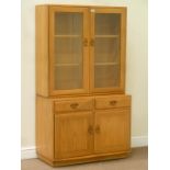 Ercol light elm display cabinet enclosed by two glazed doors fitted with adjustable shelves,