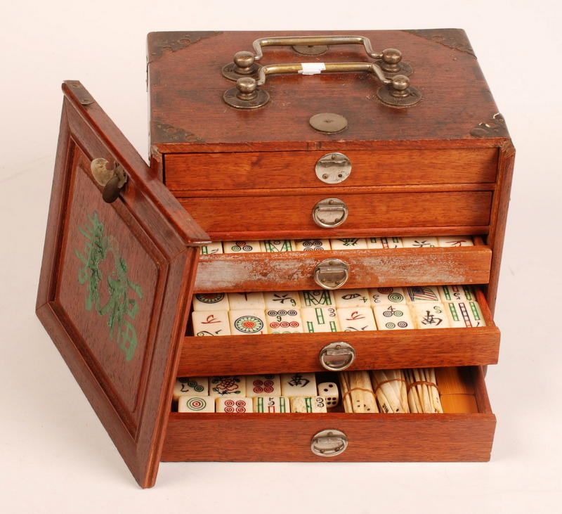 A Mahjong set in a hardwood case with a sliding front opening onto five drawers. Condition Report: