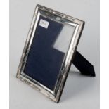 A rectangular silver photograph frame wi