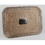 A large late Victorian Indian silver coloured metal tray of rectangular form, profusely engraved