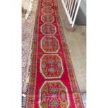 A Turkish long red ground rug with nine