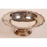 A silver circular pedestal bowl with mou