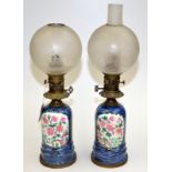A pair of oil lamps with European bronze mounts and Chinese style blue ground font, heightened