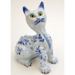 A French faience glazed blue and white character cat with glass eyes, height 20cm.