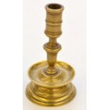 A small 17th century Dutch style brass taper stick, with a drip pan above a bell shape base,