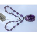 An amethyst necklace with Chinese carved amethyst pendant.  Condition Report: There is one minor