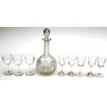 A cut glass decanter and eight cut, stemmed glasses.