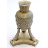 A Belleek tripod vase, black mark, 17cm. Condition Report: A chip to the rim and a couple of