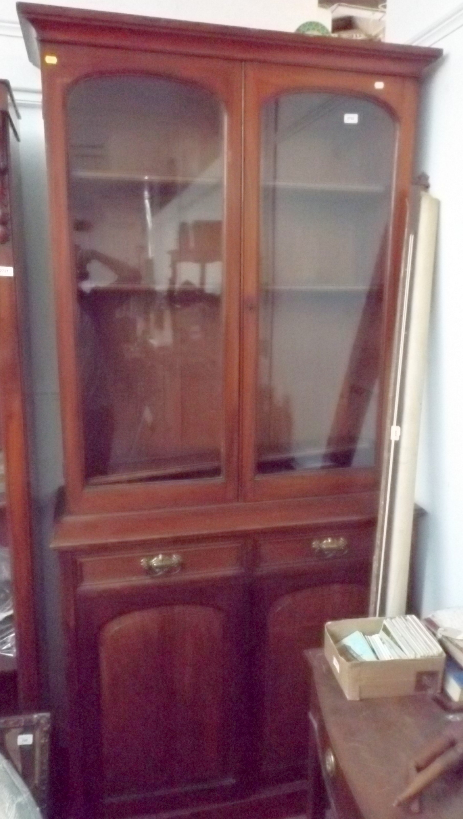 A Victorian mahogany bookcase with a pair of arched glazed doors above a pair of drawers and