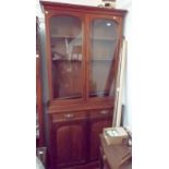 A Victorian mahogany bookcase with a pair of arched glazed doors above a pair of drawers and