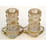 A pair of Daum Nancy candlesticks, each with polished rim above a naturalistic column on square base