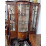 An Edwardian inlaid mahogany display cabinet with a bowed glass panel flanked by doors on square