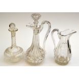 A cut glass claret jug, a Regency cut glass jug, and a cut and engraved glass decanter.