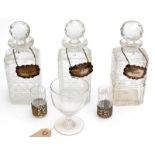 Three square section cut glass decanters with plated labels, together with a George III rummer