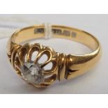 A late Victorian 18ct ring with a single diamond in a flowerhead claw setting.