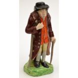 An early 19th century Staffordshire figure of an old gentleman, he walks with a stick and a crutch,