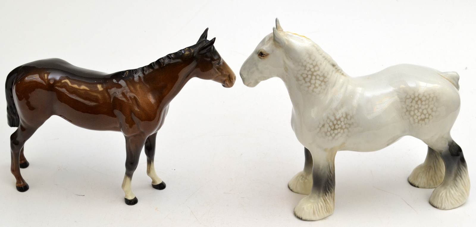 A Beswick dappled grey heavy horse with a yellow plaited mane, one ear neatly re-glued, height 21.