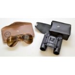 A pair of Ray-Ban Aviator sunglasses and a pair of Miranda 8x21 binoculars.