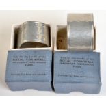 Two "Cornish tin" hammered napkin rings, each in its original box,