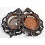 A pair of ornate, carved, oval small frames.