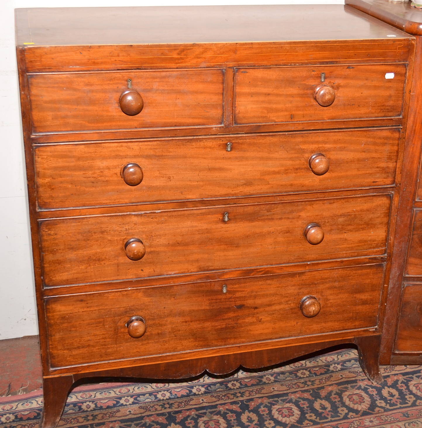A late Georgian mahogany chest of drawers with inlaid lines on splayed bracket feet, width 101cm.