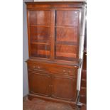 A reproduction mahogany veneered bookcase, the base with a drawer and panelled doors.