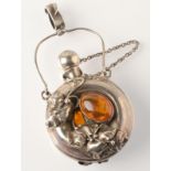 An Art Nouveau style silver perfume bottle set with amber amongst naturalistic foliage.