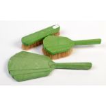 A green Art Deco plastic hand mirror by Halex and two matching brushes.