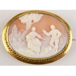 A 19th century carved cameo showing a man and woman in pastoral landscape with gold brooch mount.