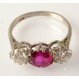 A fine platinum ring set with two diamonds, each of approximately .65ct. spread and a central ruby.