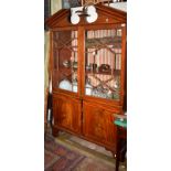 A reconstructed George III mahogany bookcase with broken arch pediment,