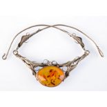 An Art Nouveau silver collar set with amber.