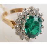 An 18ct. diamond and green stone ring.