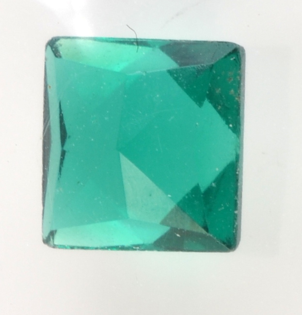 An unmounted, square cut simulated emerald.