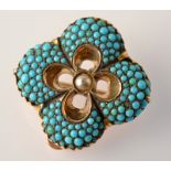 A Victorian quatrefoil gold pendant/brooch pave set with turquoise about a central pearl.