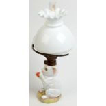 A German porcelain cat oil lamp, the kitten holds a ball and has glass eyes, the burner by Kosmos-